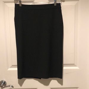 Stretch low waist pencil skirt with back slit. Zipper and pockets on the side.